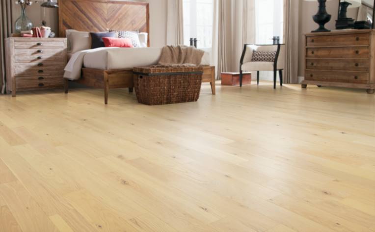 warm toned hardwood flooring in bedroom with boho decor.